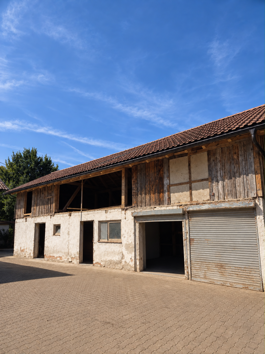 Gebäude mit alter, verwitterter Holzfassade vor der Sanierung