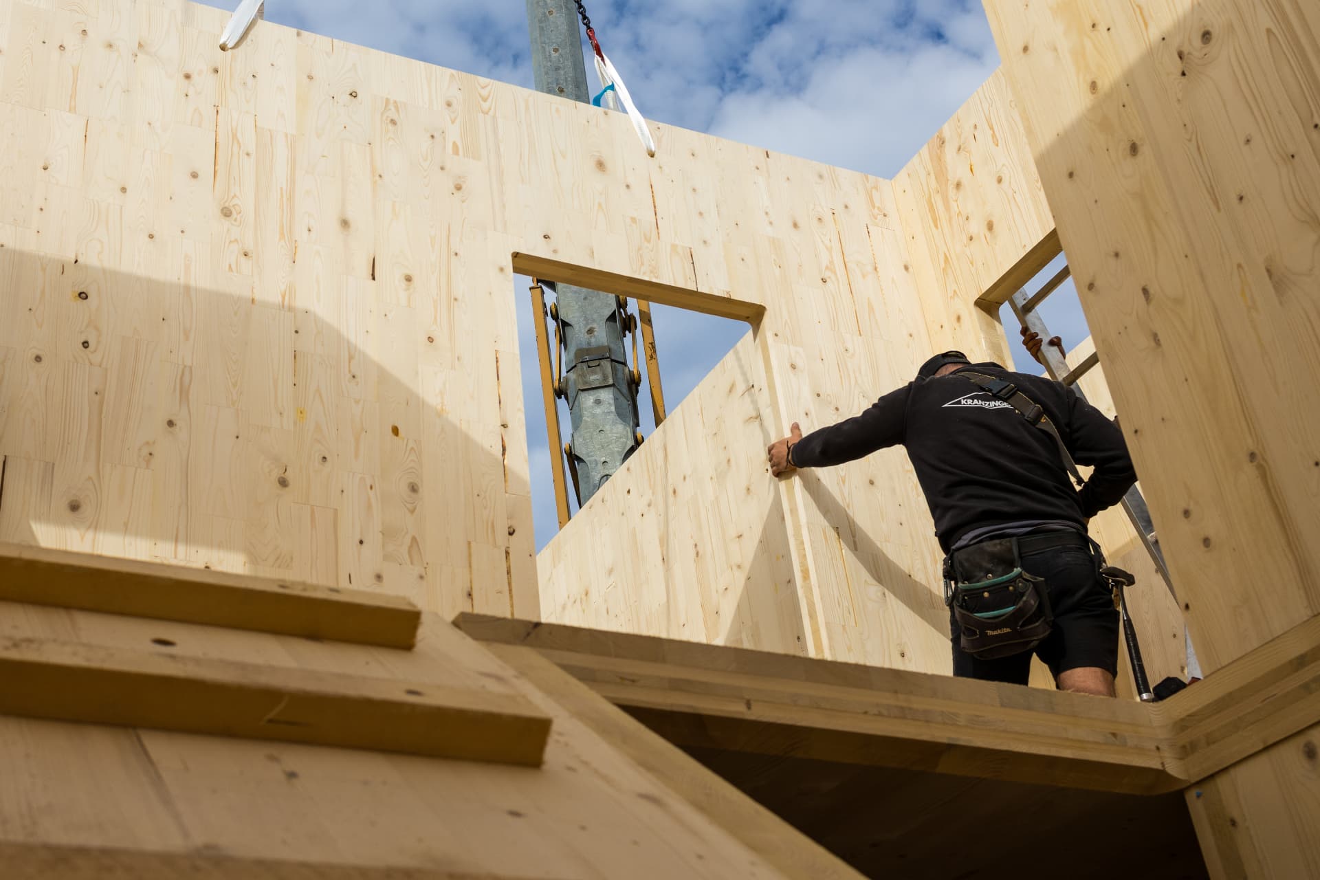 Zimmerer bei der Montage massiver Holzwände