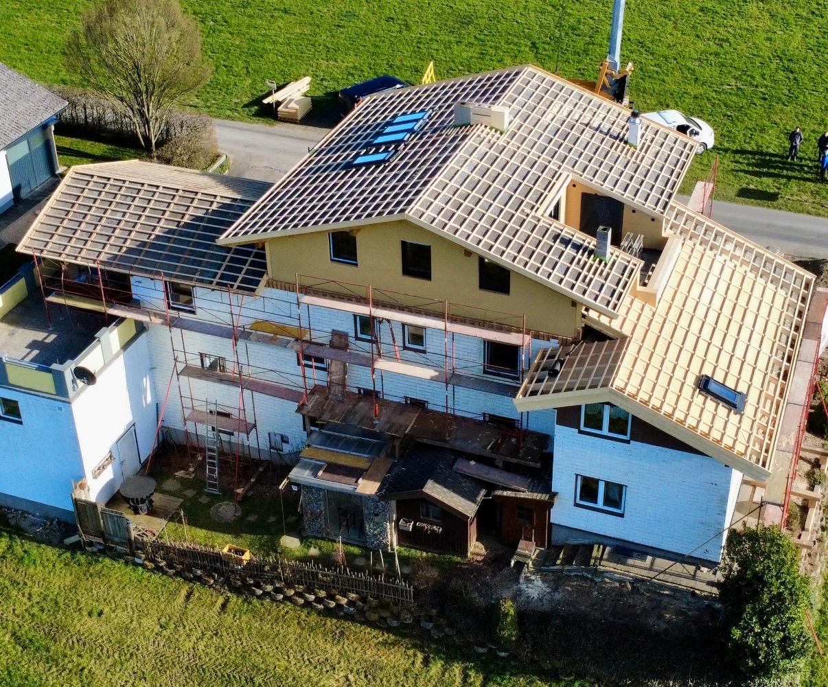 Luftaufnahme eines Hauses mit neu aufgelegter Dachkonstruktion und Gerüst