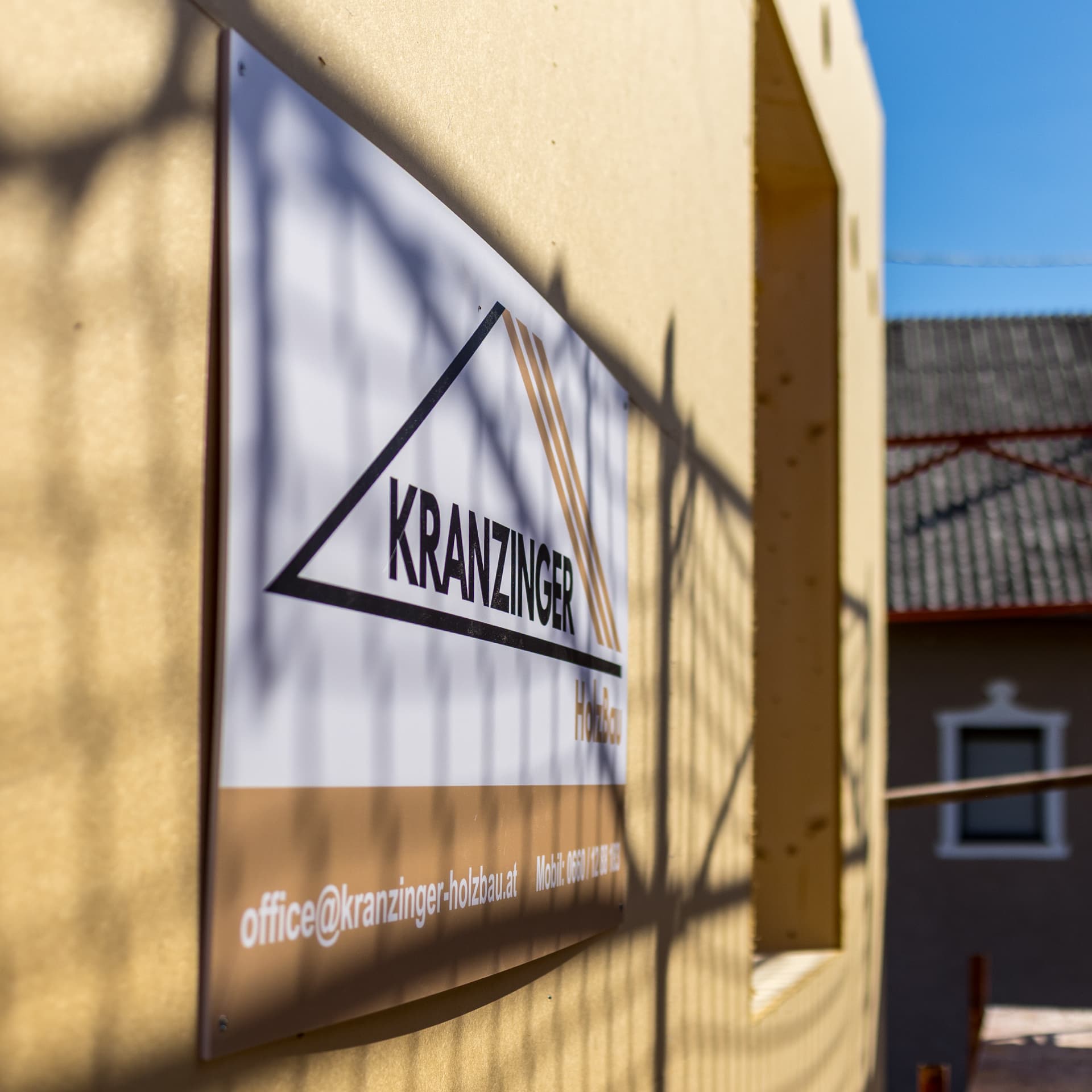 Holzbauprojekt 05 – Firmenschild von Kranzinger Holzbau am Bauholz